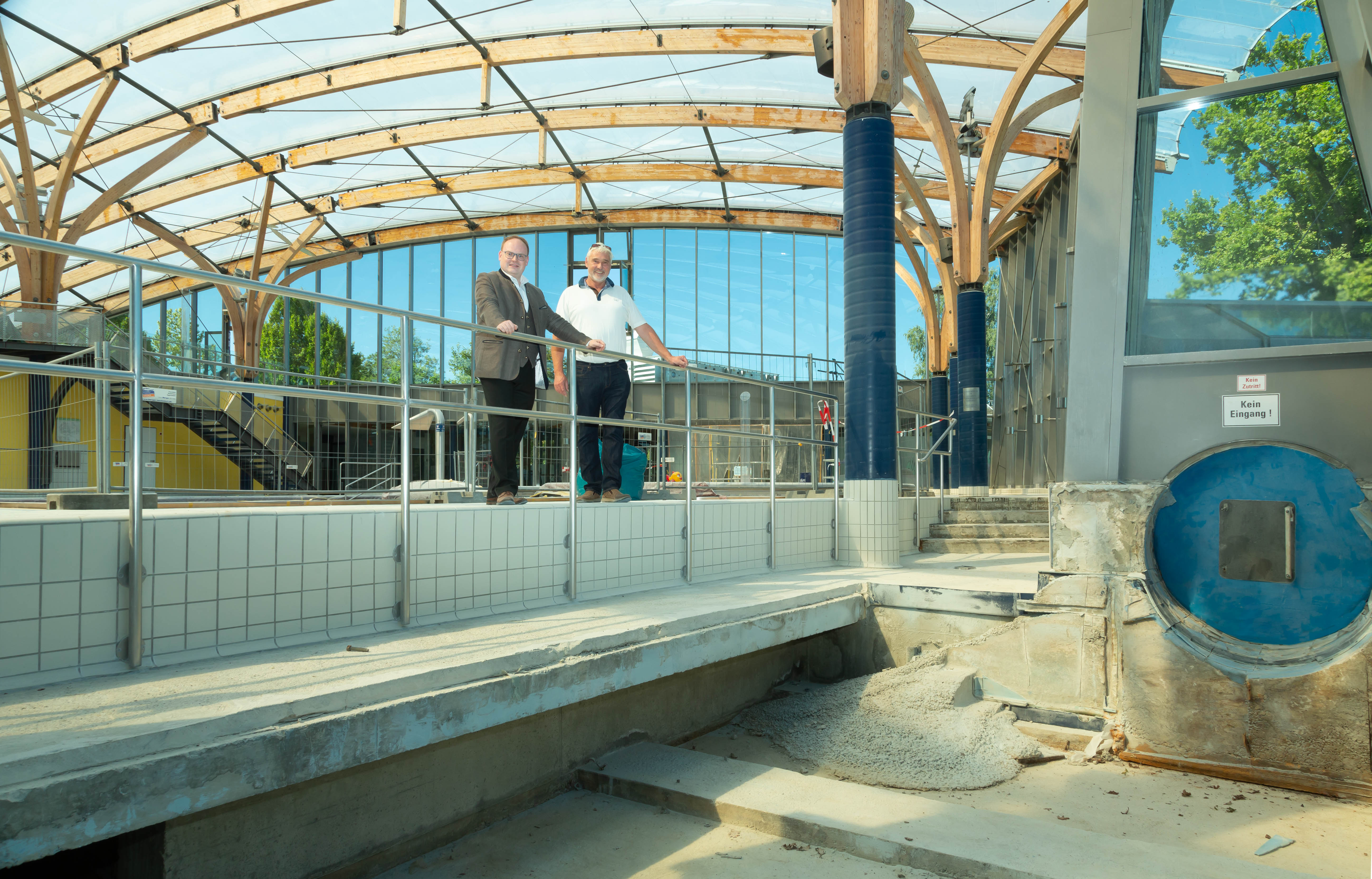 Sanierungsarbeiten im Prienavera Erlebnisbad: (v.l.n.r.) Der Erste Bürgermeister Andreas Friedrich und der Geschäftsführer der Chiemsee Marina GmbH Dirk Schröder begutachten das derzeit ausgebaute Rutschenlandebecken. Bildrechte: Anita Berger