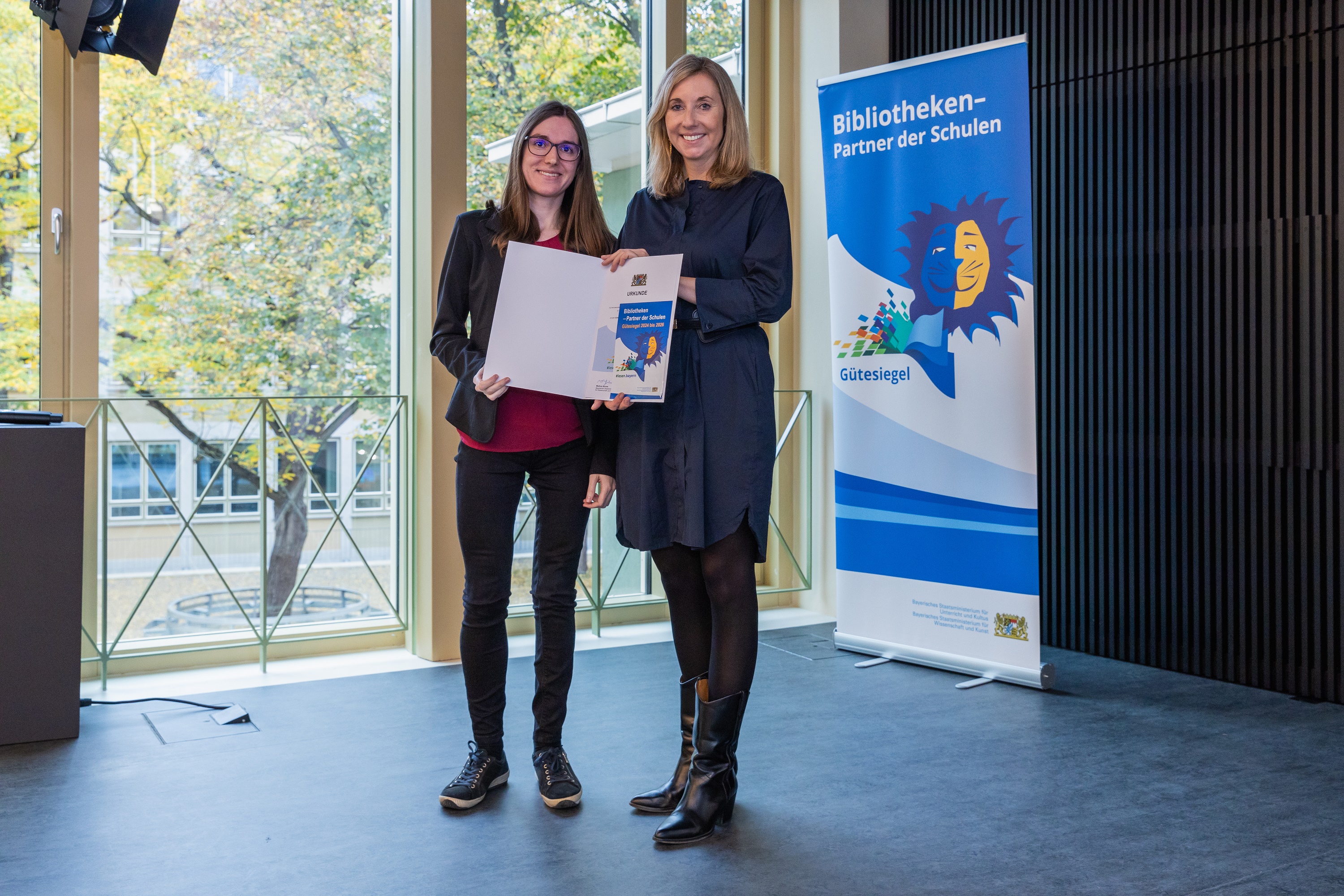 Leseförderung belohnt - Bücherei Prien ist Preisträger des Gütesiegels „Bibliotheken - Partner der Schulen 2024-2026“: (v.l.n.r.) Büchereileiterin Melanie Schieber nimmt dankend die Urkunde von Staatsministerin Anna Stolz entgegen.
Bildrechte: Johannes Kiefer
