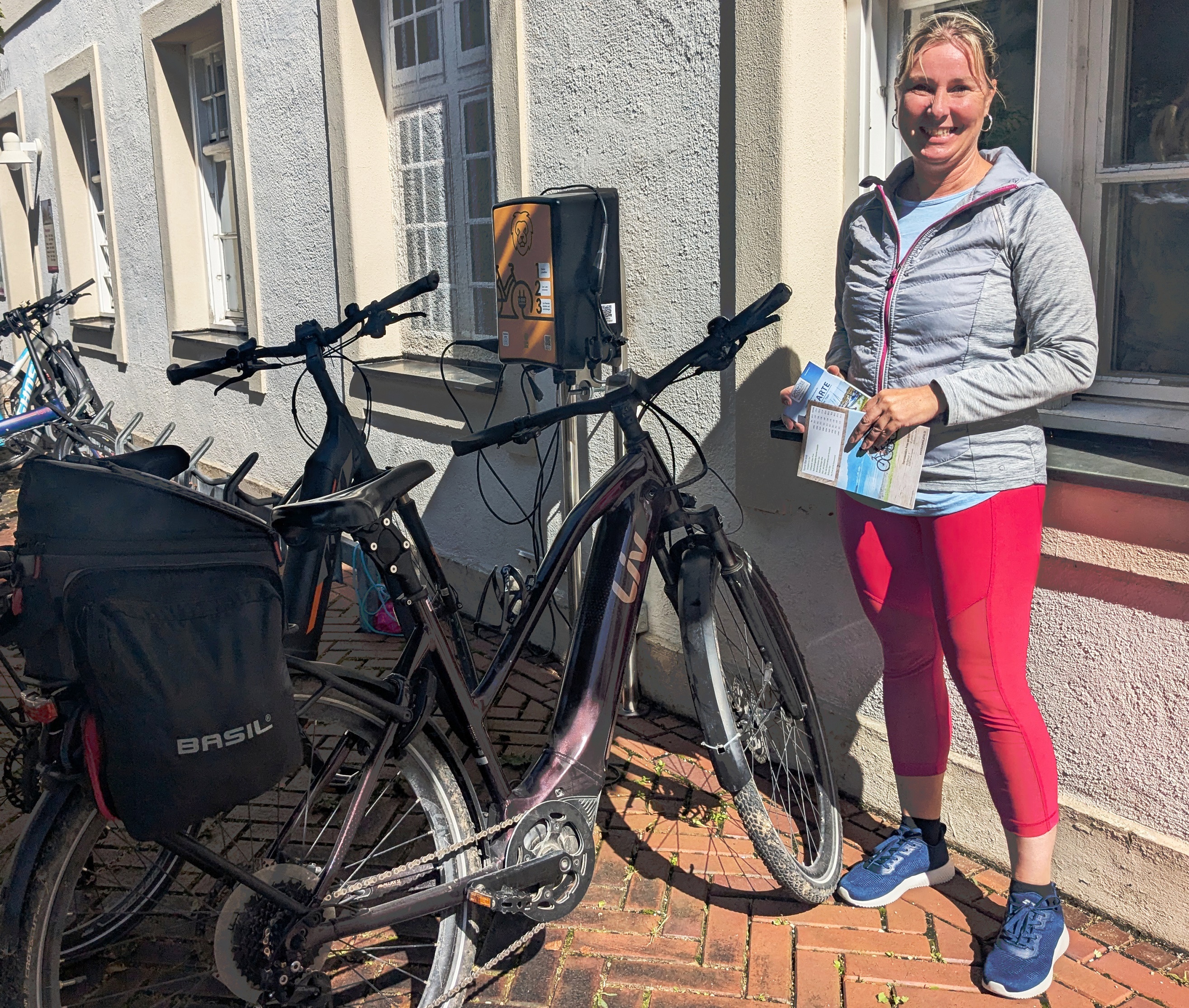 Neue E-Bike-Ladestation am Haus des Gastes wird bereits an den ersten Tagen gut angenommen: Stefanie Schober freut sich über den kostenfreien Service. Die aus Dachau stammende E-Bikerin ist derzeit auf Reha in Prien am Chiemsee und macht sich mit ihrem elektronischen Drahtesel fit fürs Skifahren im Winter.
Bildrechte: Markt Prien a. Chiemsee