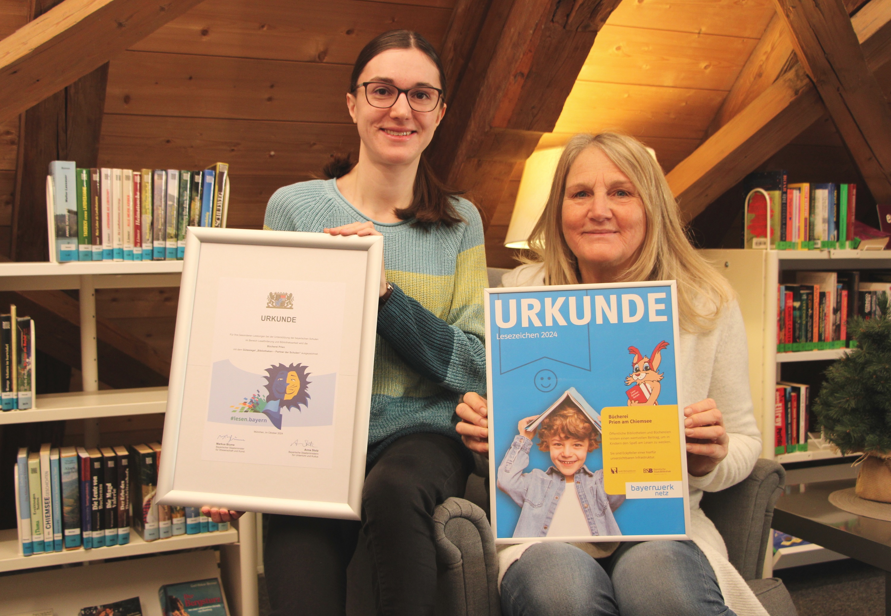 Zwei Auszeichnungen wurden der Bücherei Prien 2024 verliehen: (v.l.n.r.) Büchereileiterin Melanie Schieber mit dem Gütesiegel „Bibliotheken – Partner der Schulen“ des Bayerischen Staatsministeriums und ihre Kollegin Moni Zech mit der Urkunde „Lesezeichen 2024“, ausgezeichnet von Bayernwerk. Bildrechte: Markt Prien a. Chiemsee Zwei Auszeichnungen wurden der Bücherei Prien 2024 verliehen: (v.l.n.r.) Büchereileiterin Melanie Schieber mit dem Gütesiegel „Bibliotheken – Partner der Schulen“ des Bayerischen Staatsministeriums und ihre Kollegin Moni Zech mit der Urkunde „Lesezeichen 2024“, ausgezeichnet von Bayernwerk. Bildrechte: Markt Prien a. Chiemsee