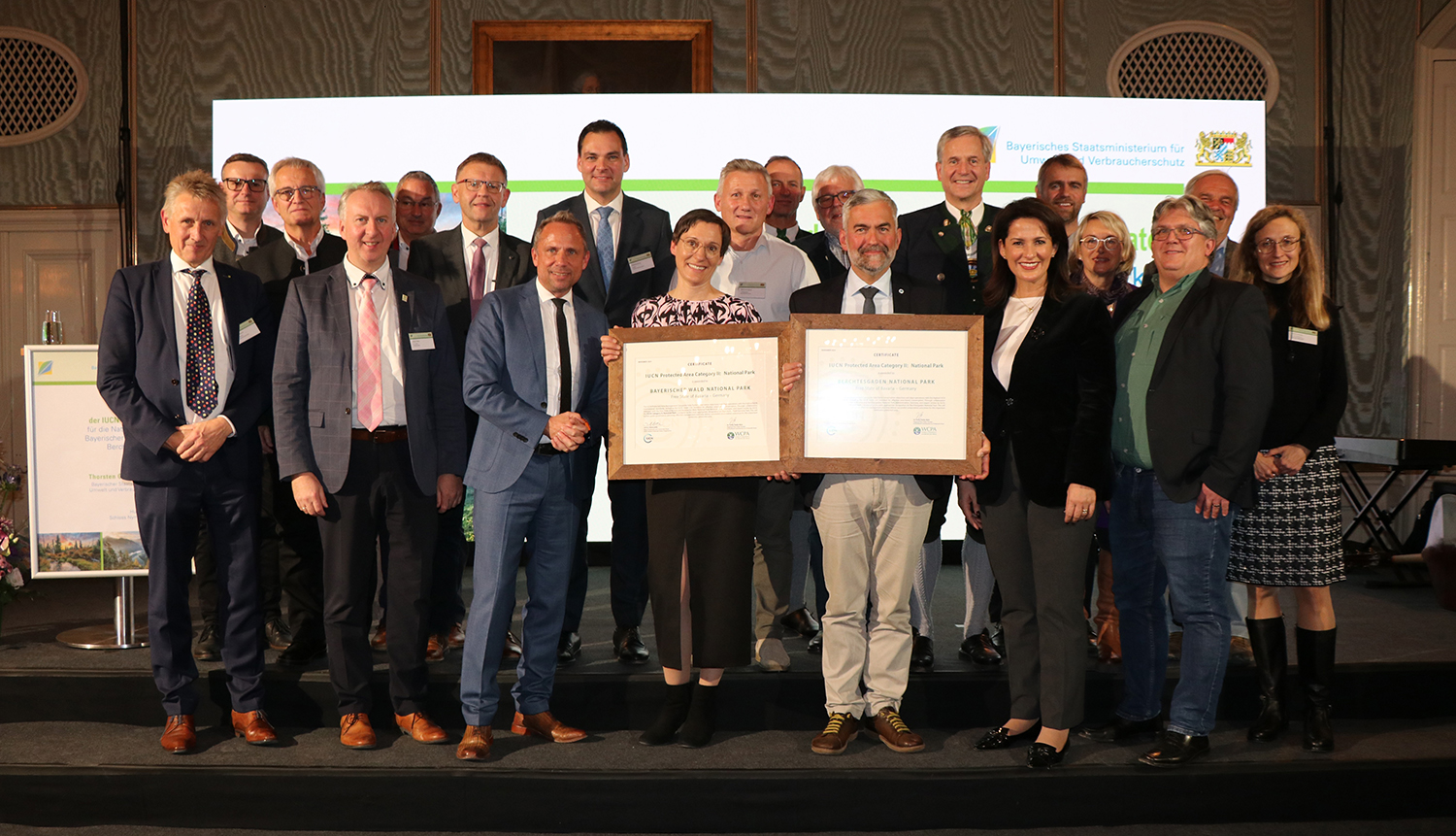 Dr. Eick von Ruschkowski, der Vertreter der IUCN, überreichte im Beisein von Staatsminister Thorsten Glauber (7.v.l.) und Staatsministerin Michaela Kaniber (6.v.r.) sowie zahlreichen Ehrengästen die Zertifikate an Nationalparkleiterin Ursula Schuster und Nationalparkleiter Dr. Roland Baier (vorne Mitte). (Foto: Nationalpark Bayerischer Wald) Dr. Eick von Ruschkowski, der Vertreter der IUCN, überreichte im Beisein von Staatsminister Thorsten Glauber (7.v.l.) und Staatsministerin Michaela Kaniber (6.v.r.) sowie zahlreichen Ehrengästen die Zertifikate an Nationalparkleiterin Ursula Schuster und Nationalparkleiter Dr. Roland Baier (vorne Mitte). (Foto: Nationalpark Bayerischer Wald)